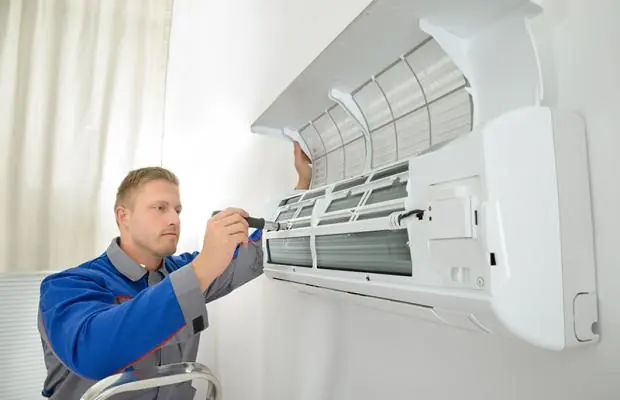 Profissional fazendo manutenção em ar-condicionado